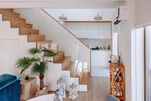 a staircase in a living room with a blue couch at The Charming Loft in Esposende +26 photos