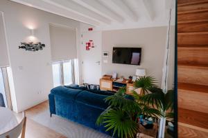 a living room with a blue couch and a tv at The Charming Loft in Esposende