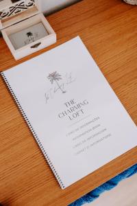 a white invitation with a palm tree on a table at The Charming Loft in Esposende