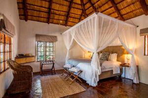 a bedroom with a bed with a canopy at Magari Safari Lodge in Vaalwater