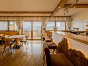 a room with a bar and tables and chairs at Hotel Elisabeth Panorama in Antermoia