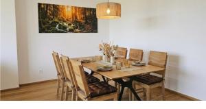 a dining room table with chairs and a painting on the wall at Moderne Ferienwohnung im Bregenzerwald in Au im Bregenzerwald +12 photos