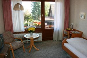 a bedroom with a bed and a table and a window at Gästehaus Schmid-Lopez in Bad Wildbad