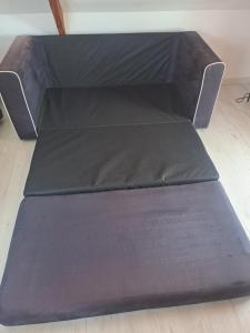 a brown couch with a black cushion on the floor at Studio cosy in Saint-Pierre-en-Val