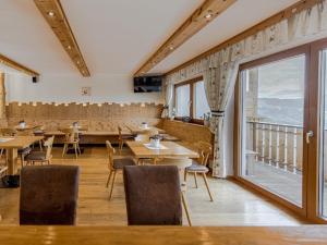 a restaurant with tables and chairs and a large window at Hotel Elisabeth Panorama in Antermoia