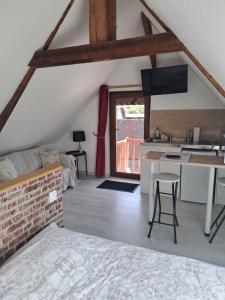 a room with a bed and a kitchen in a attic at Studio cosy in Saint-Pierre-en-Val