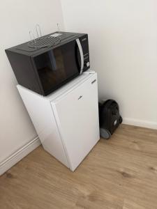 a microwave sitting on top of a white refrigerator at 1 Chambre Moyenne avec television in Charleroi