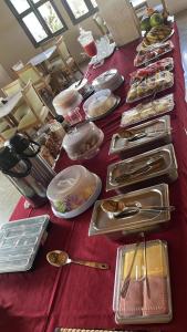 a long table with a red table cloth with food on it at Hotel Costa do Sol in Conde