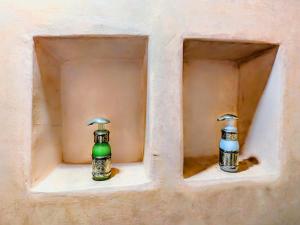 two bottles sitting on a shelf in a wall at Rooms in Dar Drouj, a special 14th century house Riad in Fez