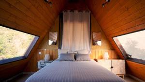 a bed in a room with two windows at Cabin with jacuzzi and spectacular views in Oliva