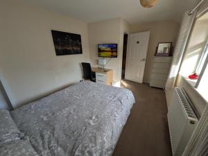a bedroom with a bed and a desk and a window at Bramcote House in Bramcote +1 photo