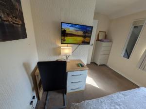 a bedroom with a desk with a lamp and a bed at Bramcote House in Bramcote