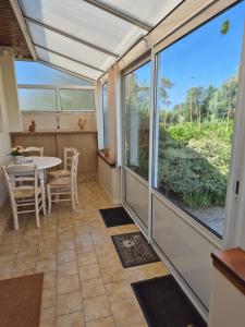 a screened in porch with a table and a window at 6 La Fiere in Sainte-Mère-Église