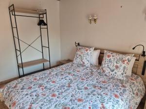 a bedroom with a bed with a floral bedspread and pillows at 6 La Fiere in Sainte-Mère-Église