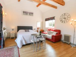 a bedroom with a bed and a table and a chair at Snowy Owl Barn in Shipdham