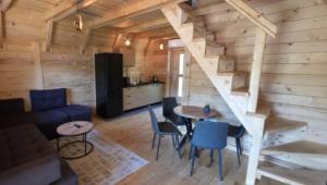 a living room with a staircase in a log cabin at Vlado Retreat in Banja Luka