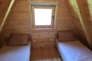two beds in a tiny house with a window at Vlado Retreat in Banja Luka +11 photos
