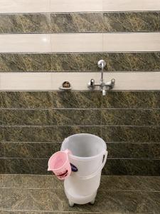 a white toilet in a bathroom with a faucet at The Amber Retreat - Best Property In Mussoorie #Luxury Rooms #Balcony #Parking #Budget Friendly #Mountain View #Restaurant #Couple Friendly in Mussoorie
