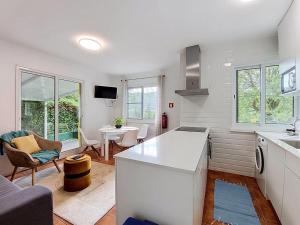 a kitchen and living room with a couch and a table at Casa Varanda das Furnas in Furnas