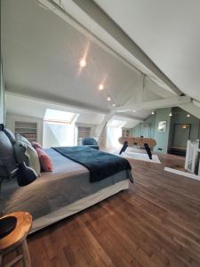 a large bedroom with a large bed and a table at L'Annexe de Steph in Loulans-Verchamp