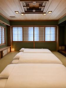 a row of beds in a room with windows at Tokyo Grand House in Akishima