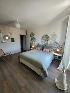 a bedroom with a large bed and wooden floors at L'Annexe de Steph in Loulans-Verchamp