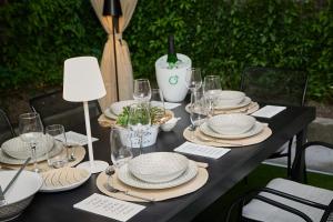 a black table with white plates and wine glasses at Gatev House in Teteven