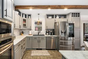 a kitchen with white cabinets and stainless steel appliances at Luxury Retreat, Views, Near Whiteface, Lake Placid in Jay