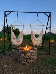 two hammocks hanging over a fire in a field at Aura House in Tsalka