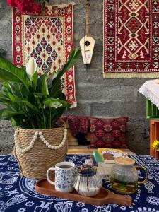 a table with a table cloth with a coffee cup and a plant at Aura House in Tsalka