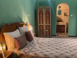a bedroom with a bed and a large door at Rooms in Dar Drouj, a special 14th century house Riad in Fez