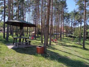 a picnic table and an umbrella in a park at Kuća za odmor Lavanda in Sirogojno
