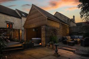 a stone building with a bath tub in a courtyard at Serenity in Painswick