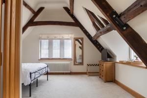 a attic bedroom with a bed and a window at Serenity in Painswick
