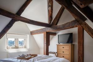 a bedroom with a bed and a tv on a dresser at Serenity in Painswick