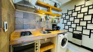 a kitchen with a sink and a washing machine at Ñireco HOUSE in San Carlos de Bariloche