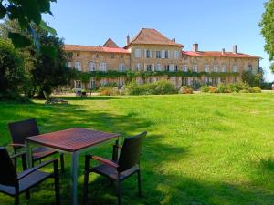 a table and chairs in front of a large building at Château D'Alteville in Tarquimpol
