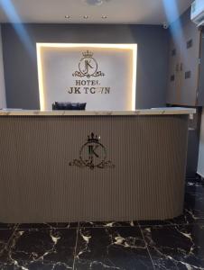 a reception desk in a hotel room with a sign at Hotel J K Town in Ahmedabad