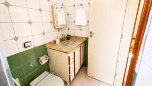 a bathroom with a sink and a toilet at No centro da cidade 750m da universidade in Viçosa +24 photos