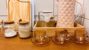 a wooden tray with three glass jars and a wooden box at No centro da cidade 750m da universidade in Viçosa