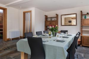 a dining room with a long table with chairs at Tranquility House in Painswick
