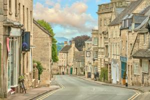 an empty street in an old town with stone buildings at Tranquility House in Painswick
