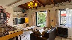 a living room with a couch and a tv at Ñireco HOUSE in San Carlos de Bariloche
