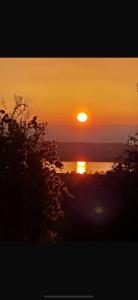 a sunset over a body of water with the sun at Reservoir View in Cheddar