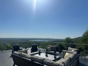 a patio with a couch and chairs on a deck at Reservoir View in Cheddar