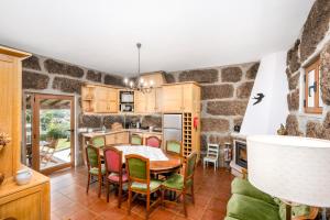 a kitchen with a table and chairs and a stone wall at Taloca Do Grilo in Baião