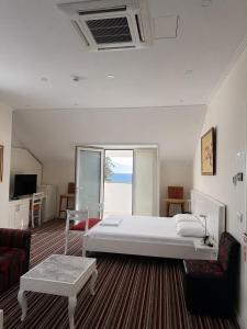 a bedroom with a bed and a couch and a table at Vila Duraku in Sarandë