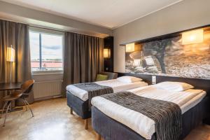 a hotel room with two beds and a window at Scandic Tampere Hämeenpuisto in Tampere +39 photos