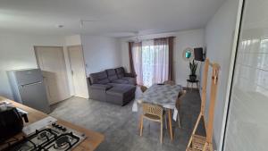 a kitchen and living room with a table and a couch at Le chant des vagues in Saint-Philippe