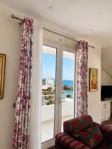 a living room with a couch and a large window at Vila Duraku in Sarandë